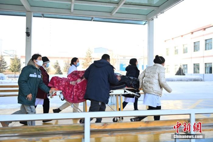 12月19日，甘肃省临夏州积石山县人民医院内，医务人员运送伤者。 中新社记者 李亚龙 摄