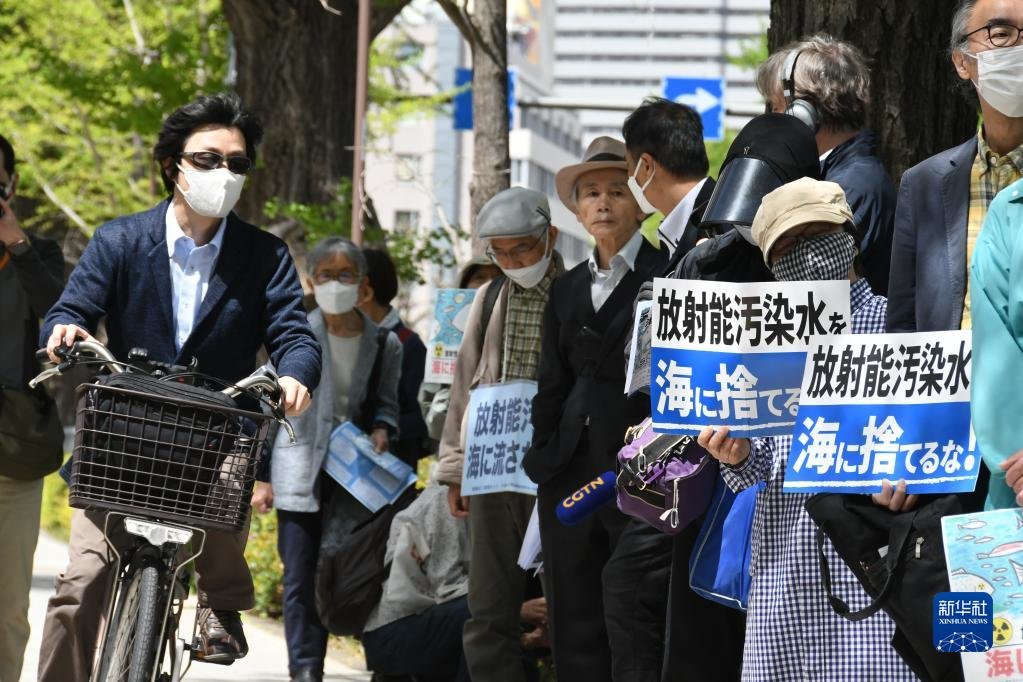 4月13日，在日本东京，民众手举标语在日本国会众议院第二议员会馆前参加集会抗议。新华社记者 岳晨星 摄