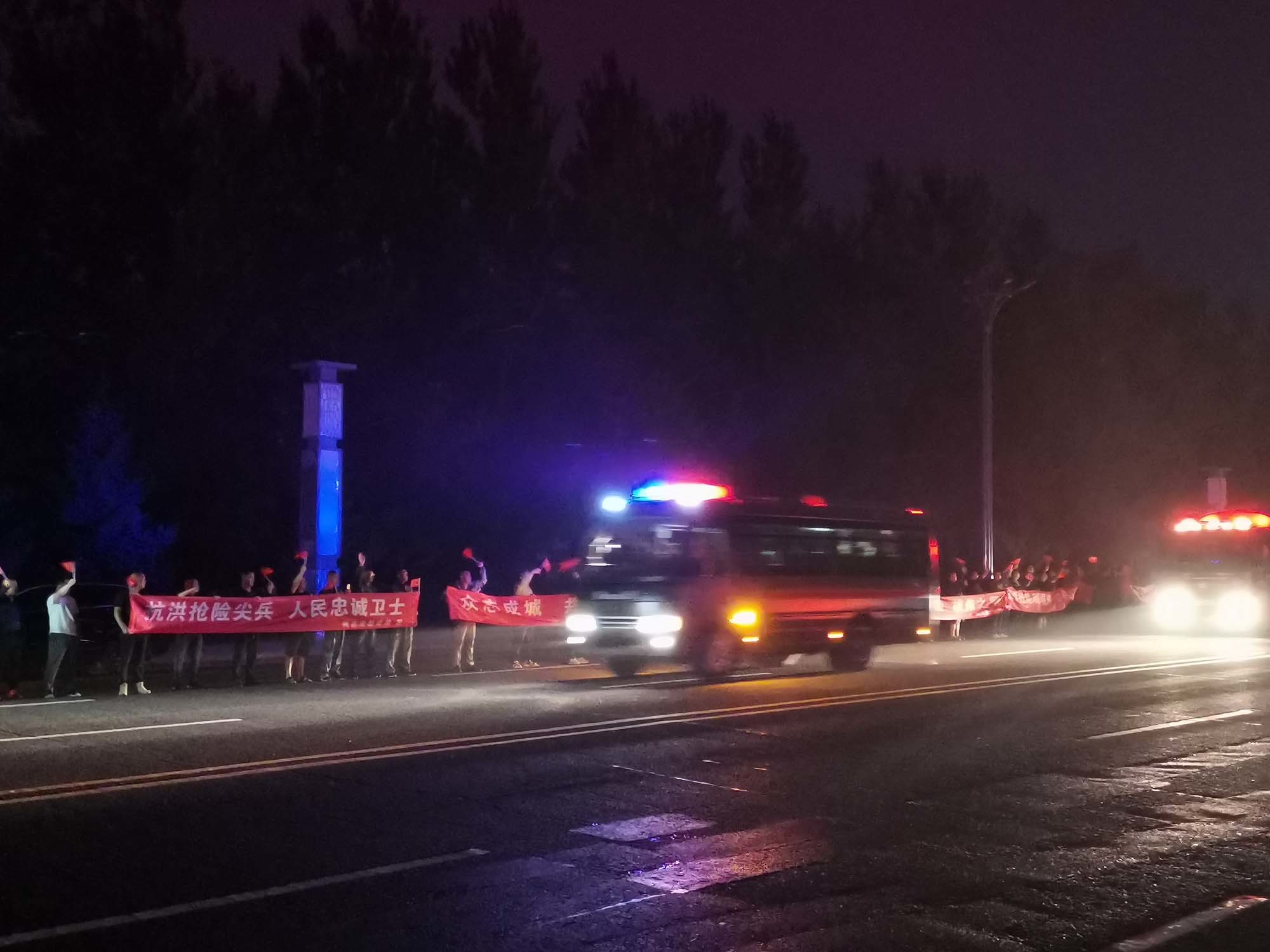 8月4日晚，一队抗洪抢险救援队伍从尚志市撤离，当地干群在高速路口给救援队伍送行。