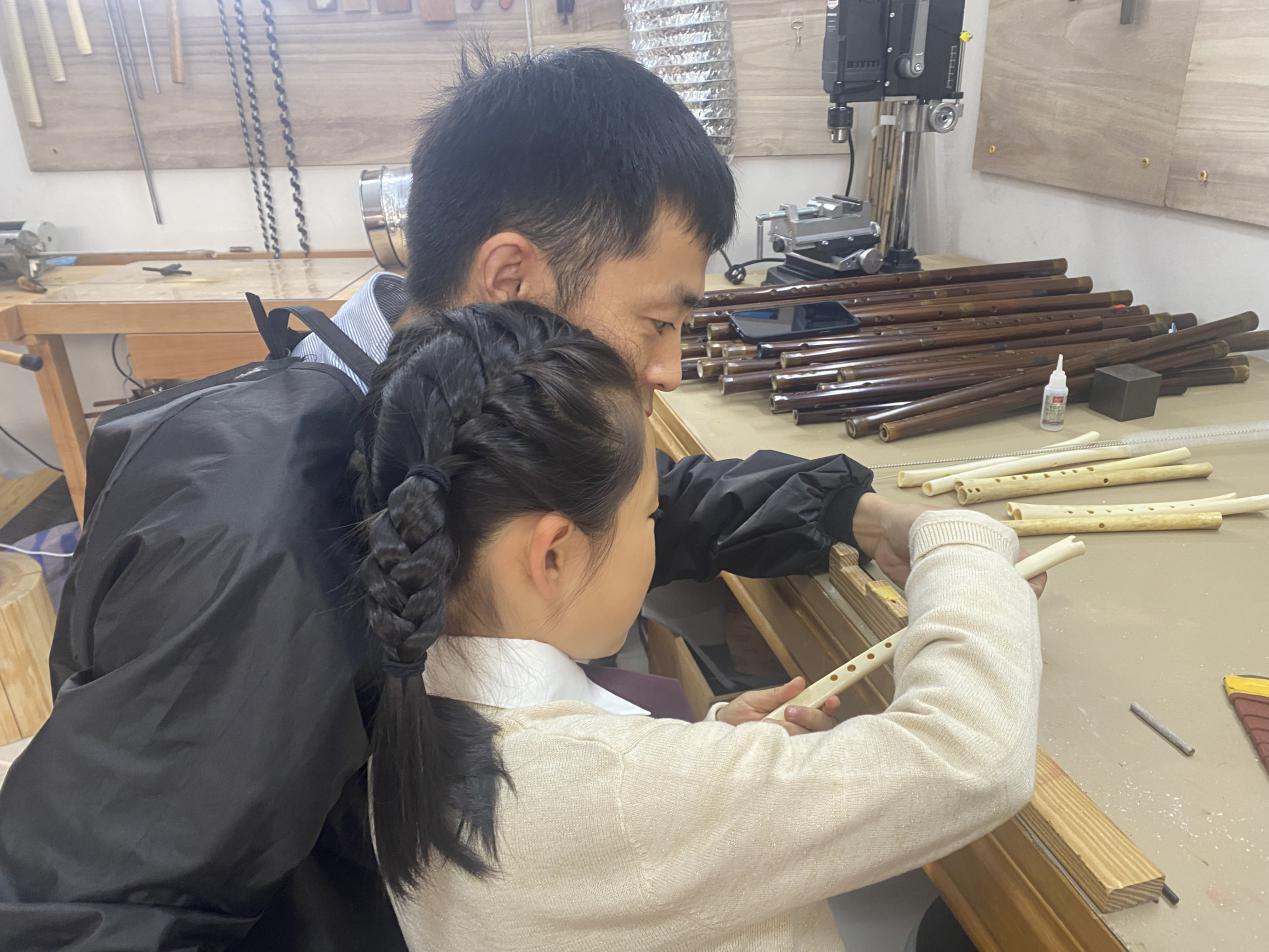 董寅聪指导女儿用砂纸打磨笛孔