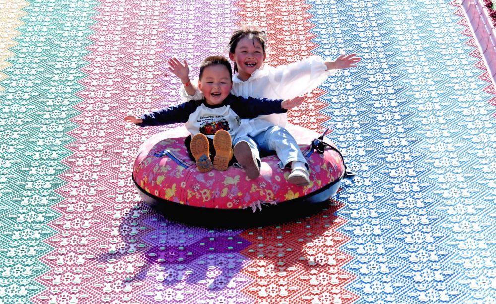 小朋友在台州市仙居县一游乐园体验七彩滑道。