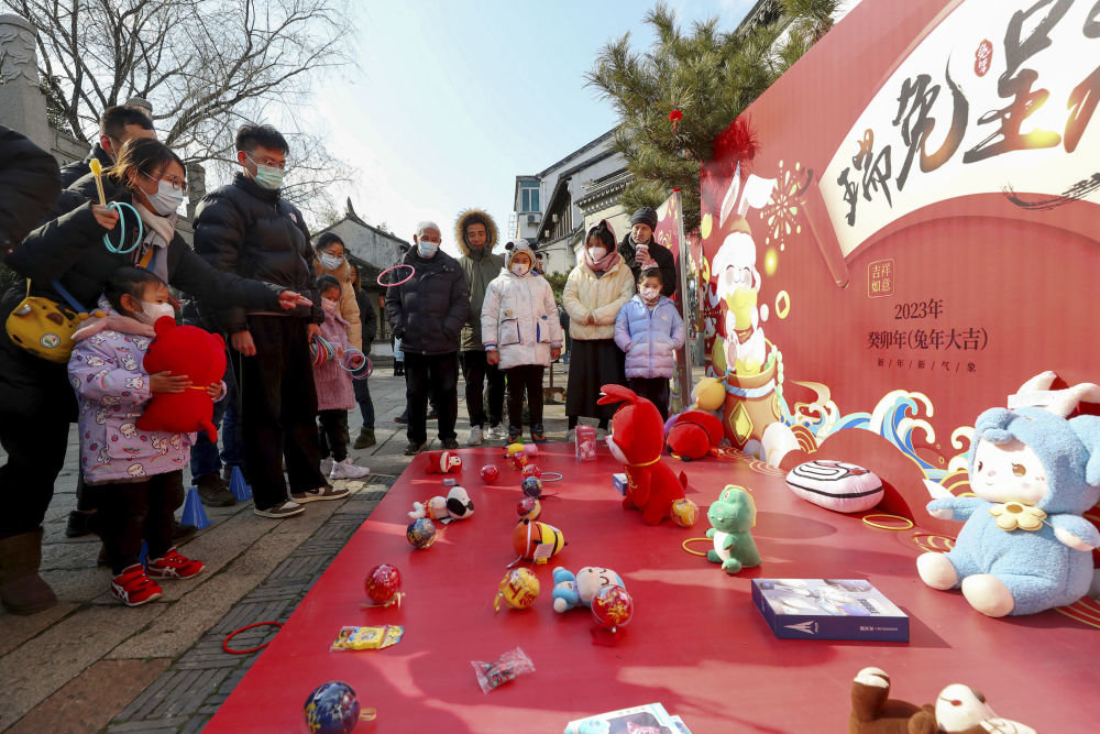 ↑1月24日，游客在苏州黎里古镇玩套圈游戏。新华社记者 方喆 摄