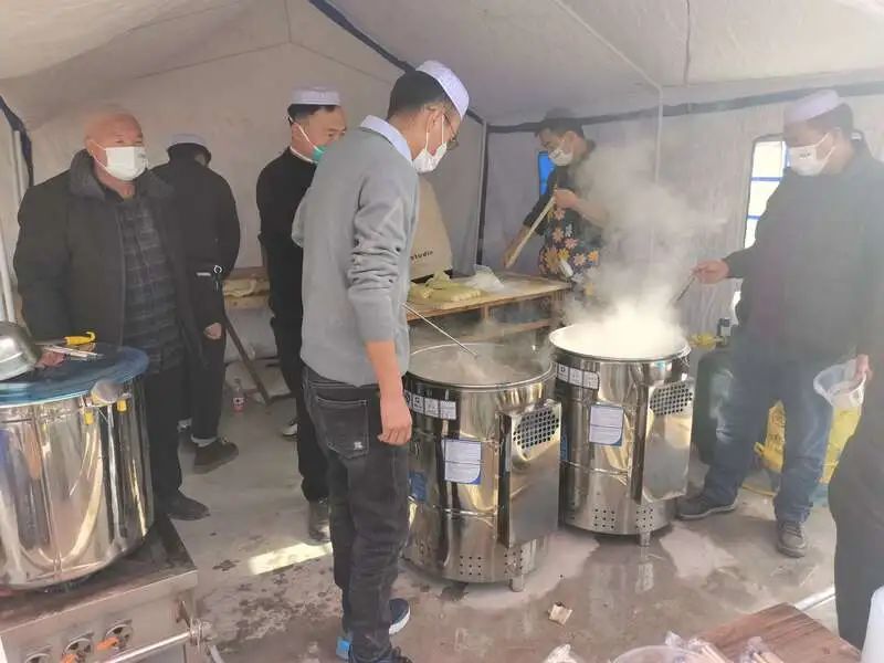 12月19日，甘肃临夏州积石山县大河家镇，村民们在帐篷里煮牛肉面，免费分发给受灾村民和救援人员。中青报·中青网记者 马富春/摄