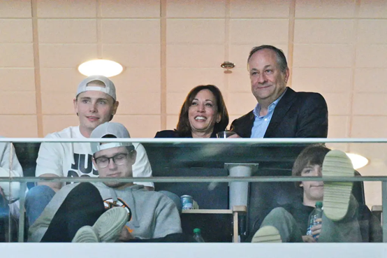 2023年3月16日,哈里斯和她的丈夫道格拉斯·埃姆霍夫(右)观看霍华德大学野牛队对阵堪萨斯大学松鹰队。图源:美媒