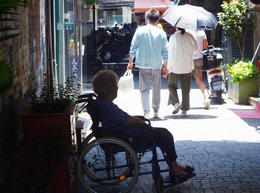 2023年6月10日，上海高温，在弄堂阴影处躲避烈日的老人。