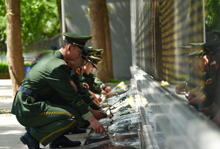 ↑武警重庆总队执勤第一支队在邱少云烈士纪念馆开展祭扫活动，官兵向革命英烈敬献鲜花（2023年4月5日摄）。新华社发（郭传伍 摄）