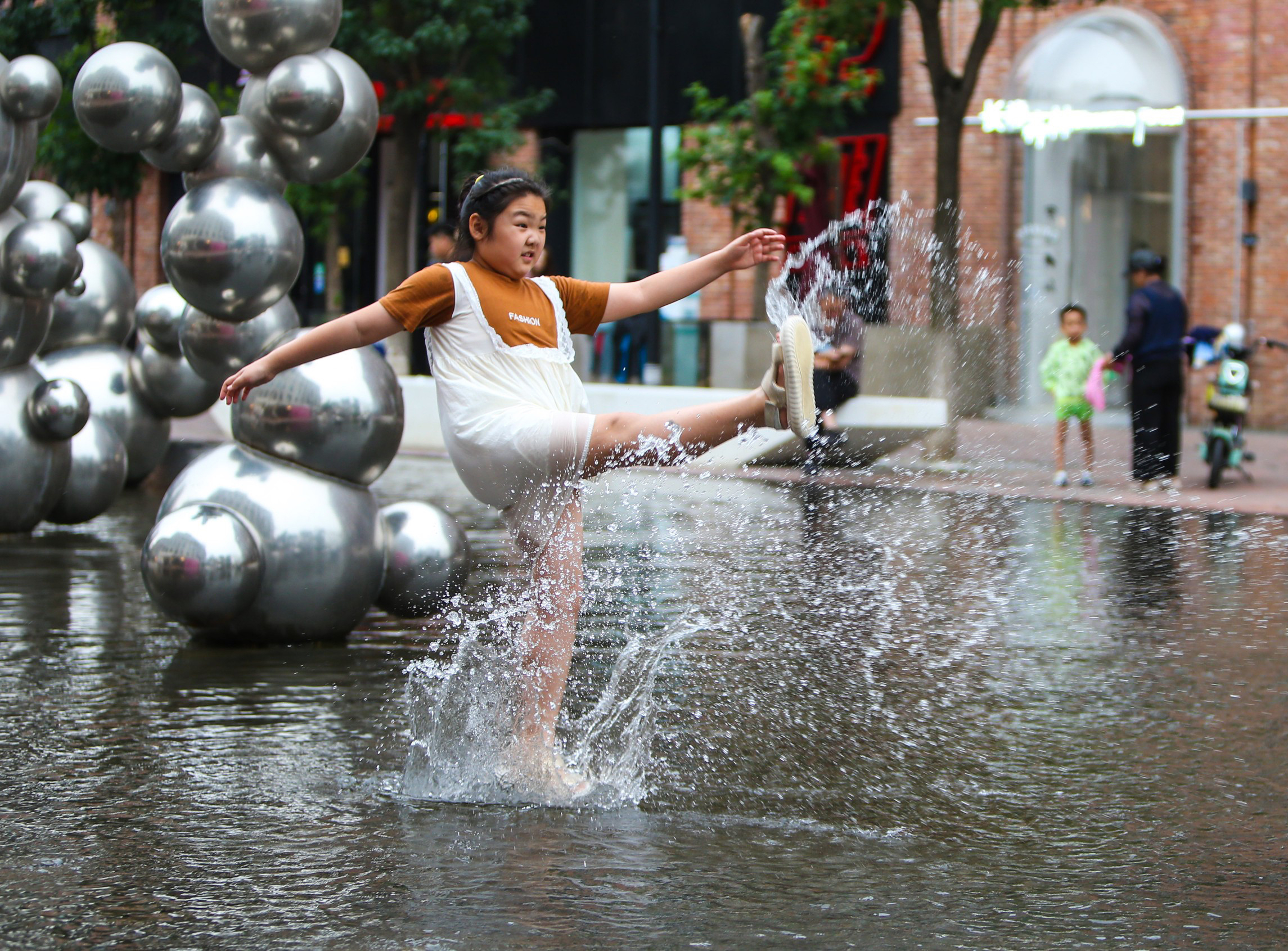 2023年6月28日，辽宁沈阳，高温天气持续。孩子们在水池里清凉消暑。