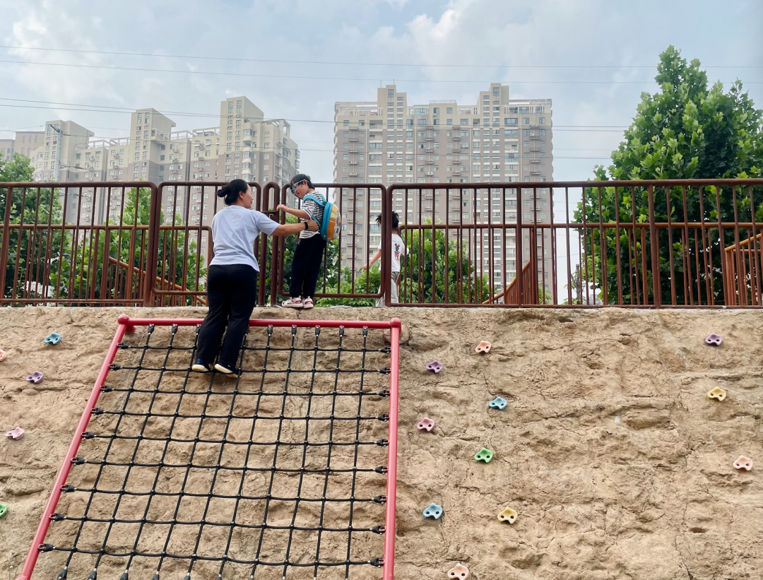 〓 2023年6月，郑州市奇色花幼儿园，老师正在辅助一位特殊孩子下斜坡。摄：张楠茜‍‍‍