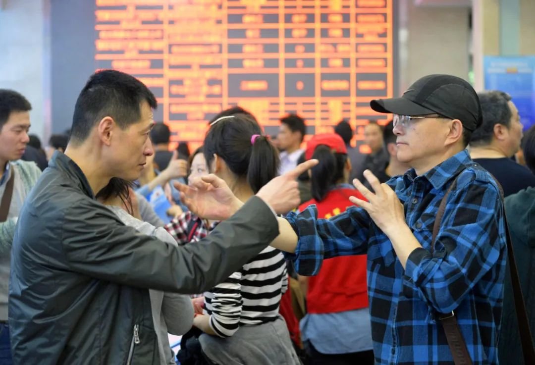 一次招聘会的现场,两名聋哑人职者在招聘会现场用手语进行交流。 视觉中国供图(资料图片)