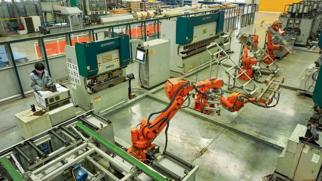 湖州南浔经济开发区某快速电梯公司生产车间内，工人们正操作智能机械臂生产线 图源：视觉中国