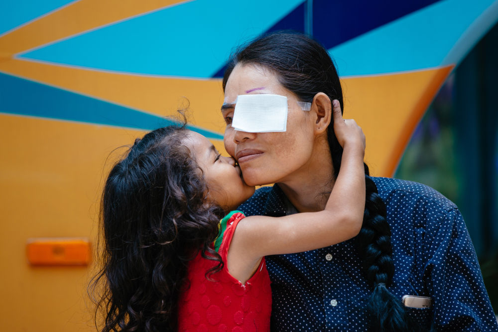 ↑这是2019年3月15日，在柬埔寨磅湛省医院，即将接受白内障手术的患者孙美乐接受女儿的亲吻祝福。孙美乐是柬埔寨一名贫困的单身母亲，左眼患上白内障几近失明。在接受了中国医疗队的白内障义诊手术后，她的视力逐步恢复，生活有了新的光明和希望。新华社记者 朱炜 摄