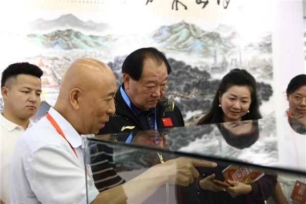 北京祥体育博物馆馆长李祥向中国首位奥运会冠军许海峰介绍展品