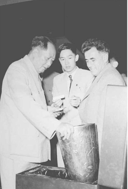 毛泽东接见南共代表团团长维塞林诺夫并观看南共向毛泽东赠送的民间工艺品:一支由南斯拉夫手工艺人制作的雕花银瓶。这是阎明复第一次给毛泽东做翻译