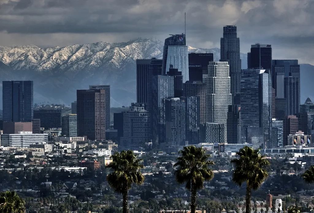 当地时间2023年2月26日，美国加利福尼亚州，洛杉矶市中心后面的圣加布里埃尔山脉上空出现了风暴云和降雪。图/视觉中国