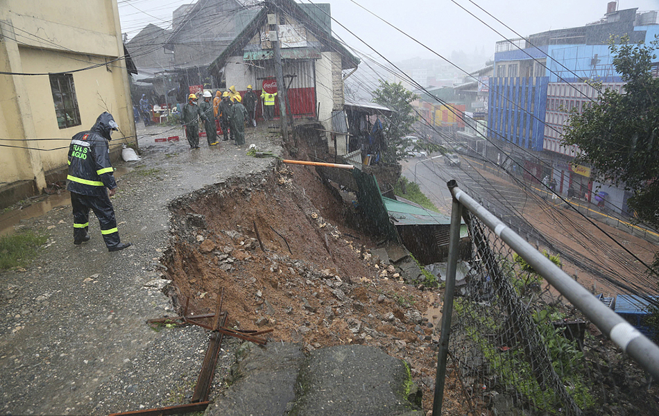 当地时间2023年7月26日,菲律宾碧瑶市,一名警察正在检查由台风“杜苏芮”造成的山体滑坡。