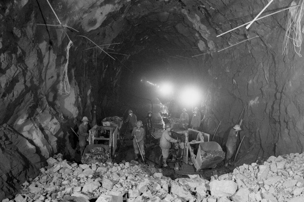 1982年,铁道兵第八师指战员在引滦入津工程隧道施工中人工装运石渣。新华社发