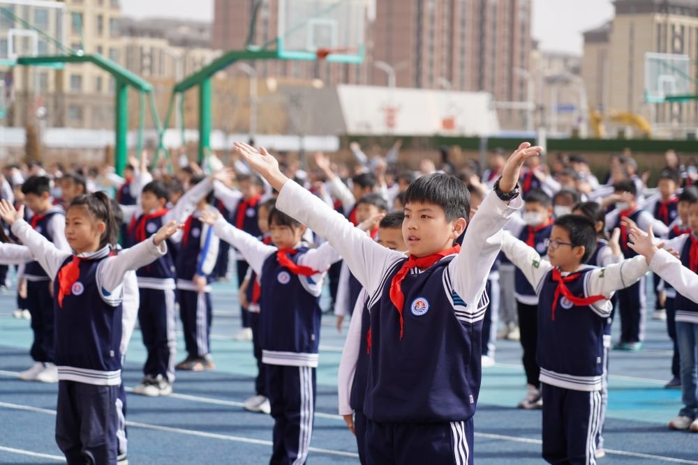 雄安新區容西片區雲溪小學的學生在操場上做操（2023年3月23日攝）。新華社記者 牟宇 攝