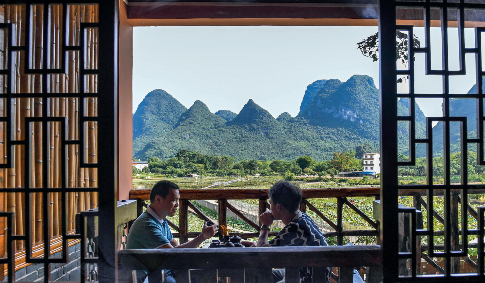 游客在广西桂林市阳朔县一家民宿喝茶聊天(2020年7月4日摄) 曹祎铭摄/本刊
