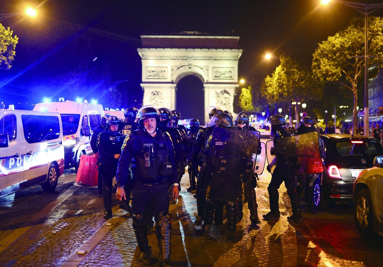 2日，法国因“警察射杀17岁少年”事件而引发的全国骚乱进入第六天。图为当地时间7月1日晚，法国警察在巴黎香榭丽舍大街的凯旋门前巡逻。（ 法新社）