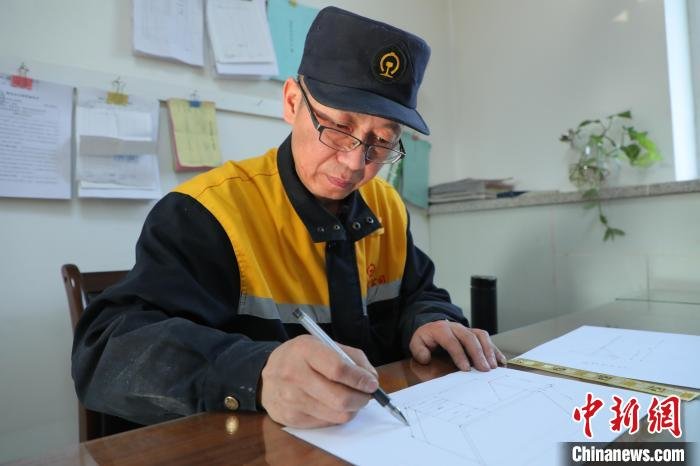 图为梁军正在绘制设计图纸。 周悦翔 摄