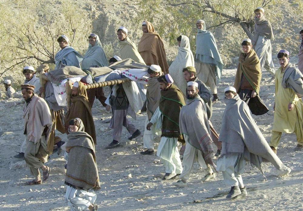 这是2001年12月19日，阿富汗托拉博拉地区的一群村民为一个被集束炸弹炸死的22岁年轻人送葬。这名年轻人在捡柴火的时候被一枚集束炸弹炸死。新华社发