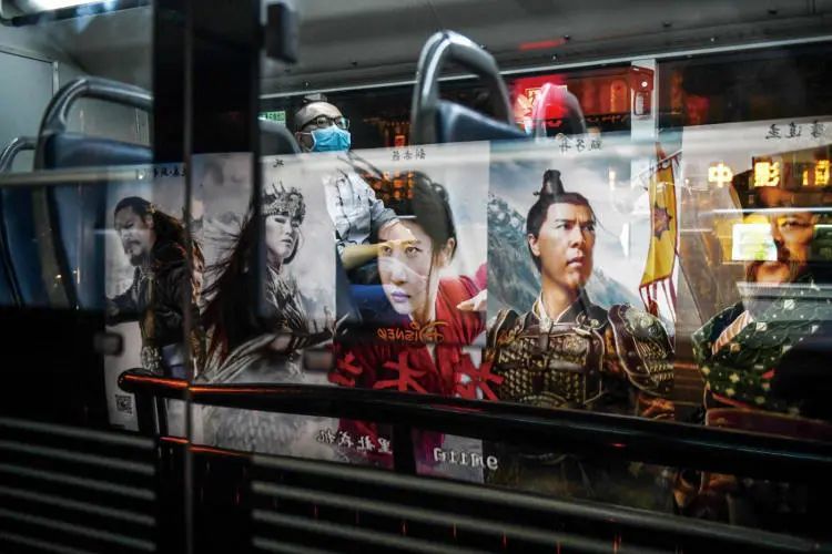2020年9月10日，北京。公交车车窗上倒映出电影《花木兰》的海报。（图/视觉中国）