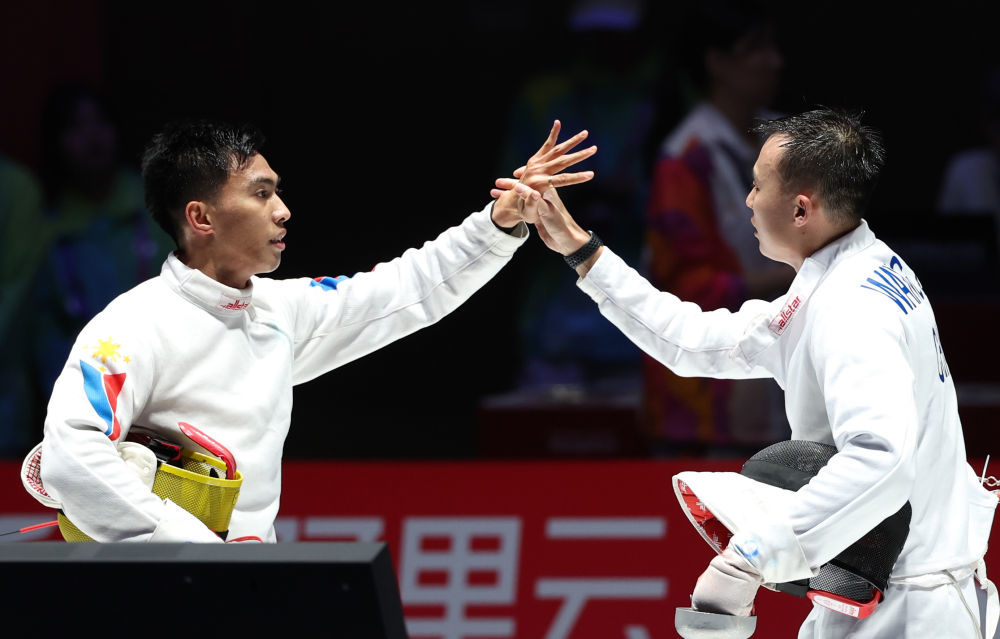 9月26日，中国选手王子杰（右）在男子个人重剑八分之一决赛赛后与菲律宾选手诺埃利托·何塞致意。