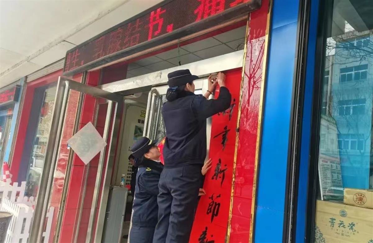 城管人员帮商户贴上新春联