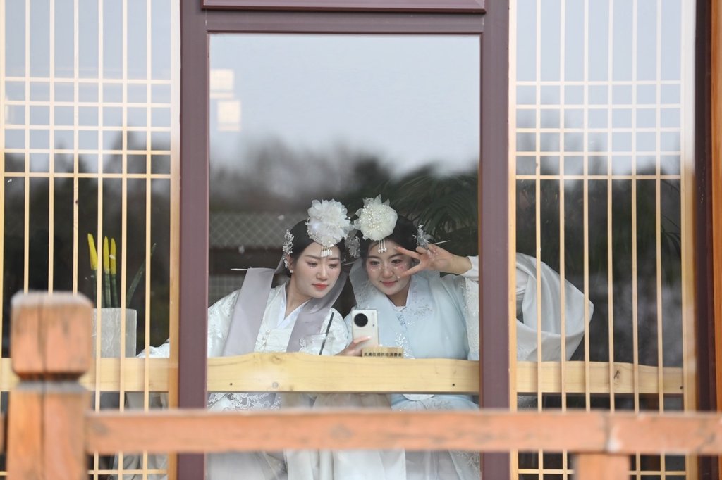 4月13日,在吉林省延边朝鲜族自治州延吉市的中国朝鲜族民俗园内,游客身着朝鲜族服饰拍照留念。吉林省延边朝鲜族自治州是中国最大的朝鲜族聚居地,当地依托特色旅游资源,吸引众多游客来此观光旅游。 中新社记者 张瑶 摄