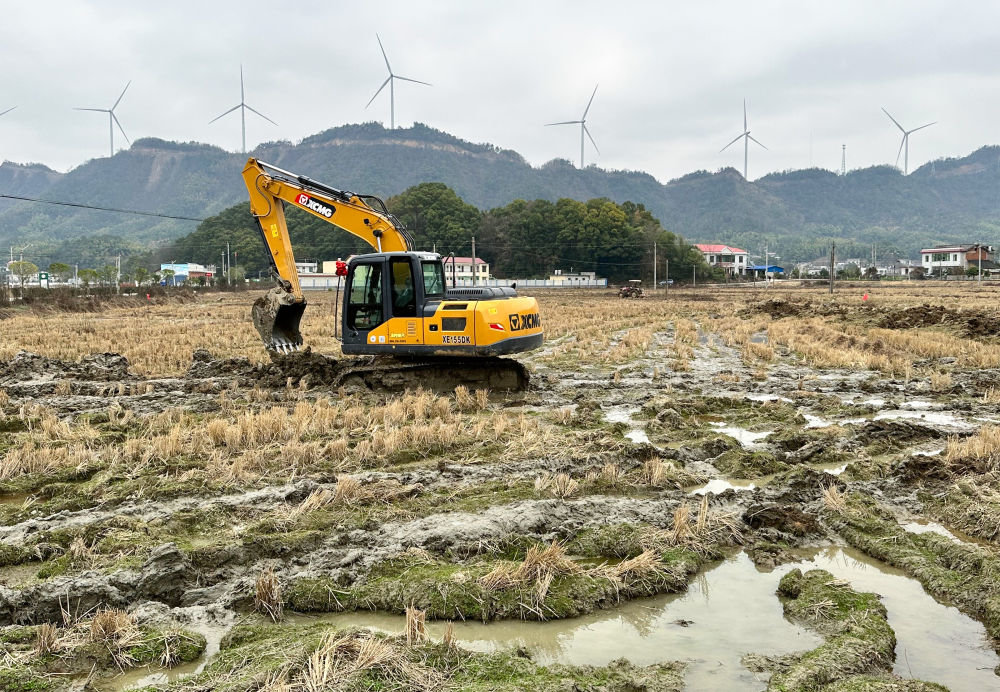 1月14日，在湖南省湘乡市梅桥镇一处高标准农田建设现场，工人驾驶挖掘机平整土地。新华社记者 谢奔 摄