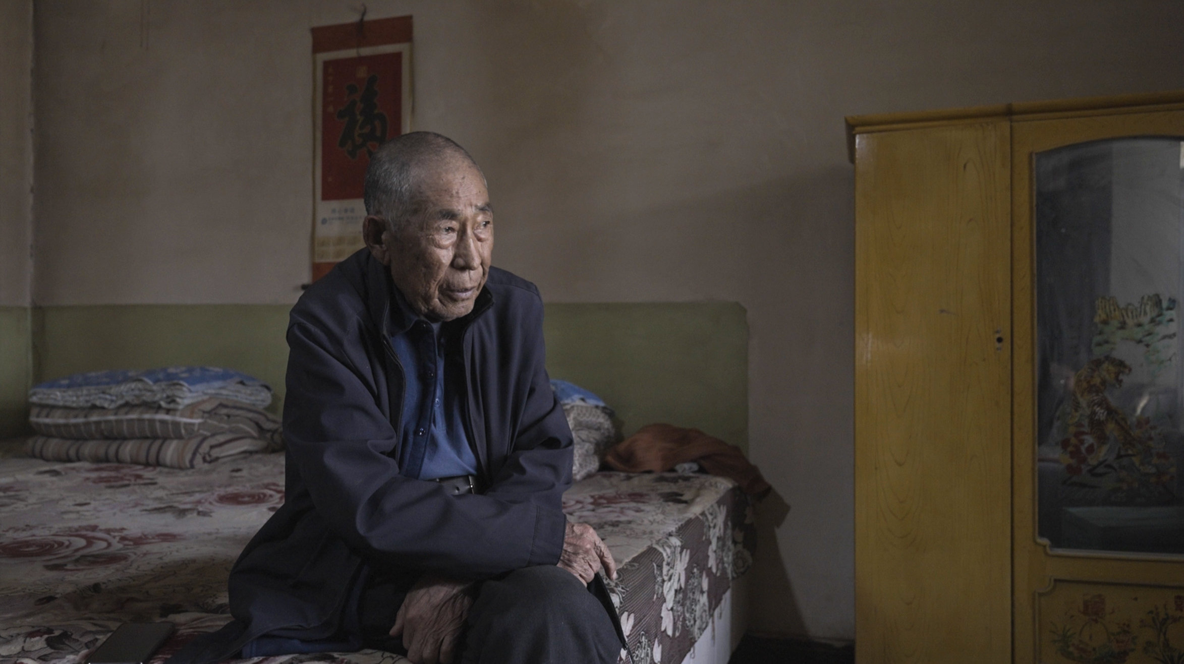 5月14日,何承祥坐在中坪村家中的炕上。