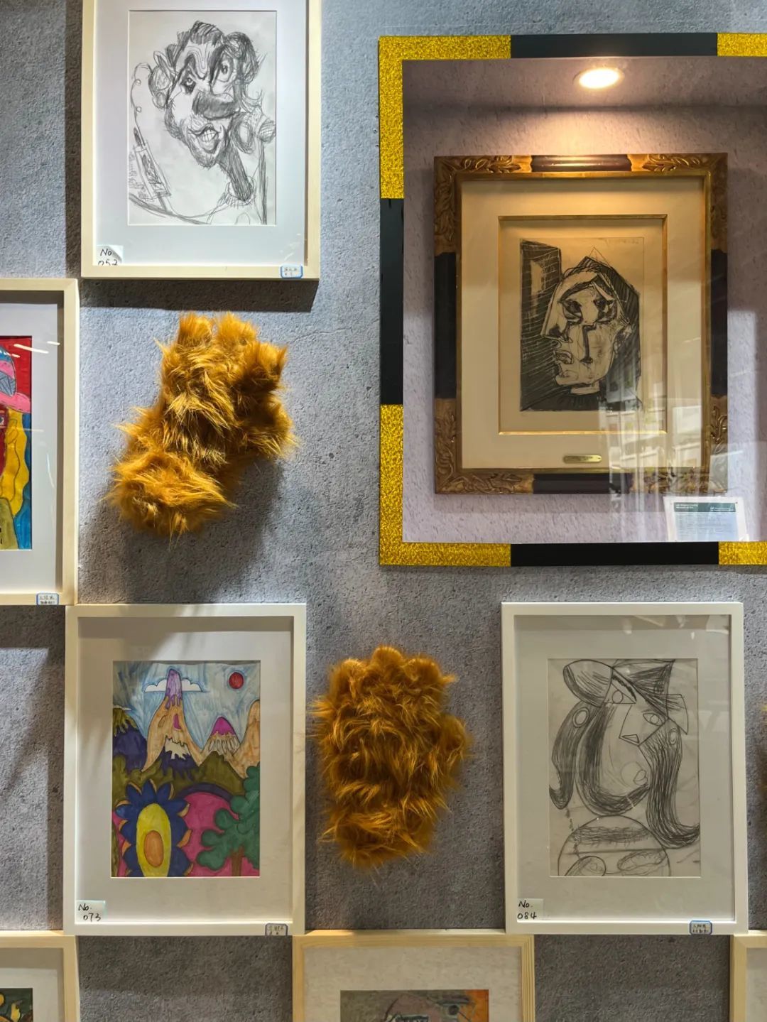 上海兴业太古汇熊爪咖啡店，由孤独症儿童创作的毕加索风格画组成的画展。金色画框里放着一副收藏家出借的毕加索画作。摄影/本刊记者 龚怡洁