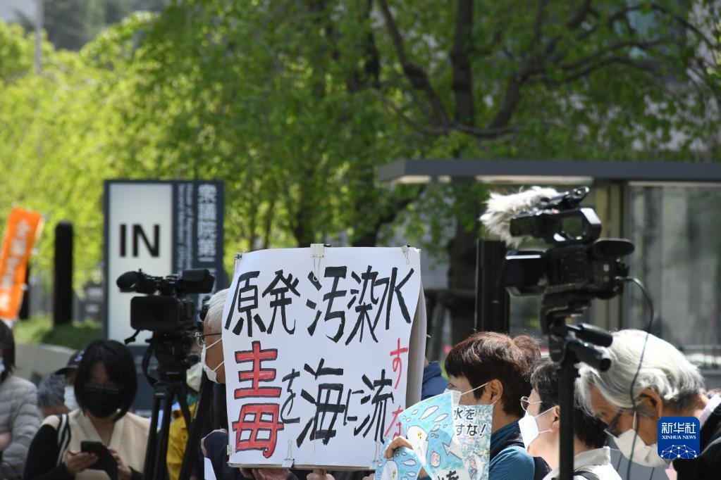 4月13日，在日本东京，民众手举标语在日本国会众议院第二议员会馆前参加集会抗议。新华社记者 岳晨星 摄