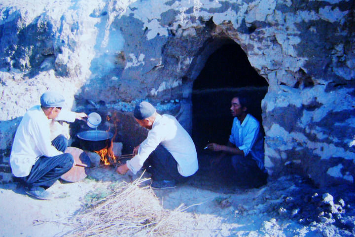 1983年，八步沙“六老汉”第一代治沙人在“地窝子”生火做饭。八步沙林场供图