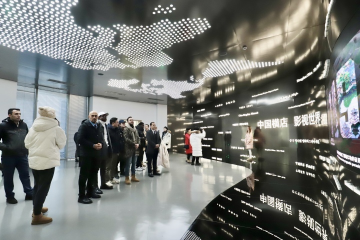 讲解员向各国网红达人介绍横店影视城