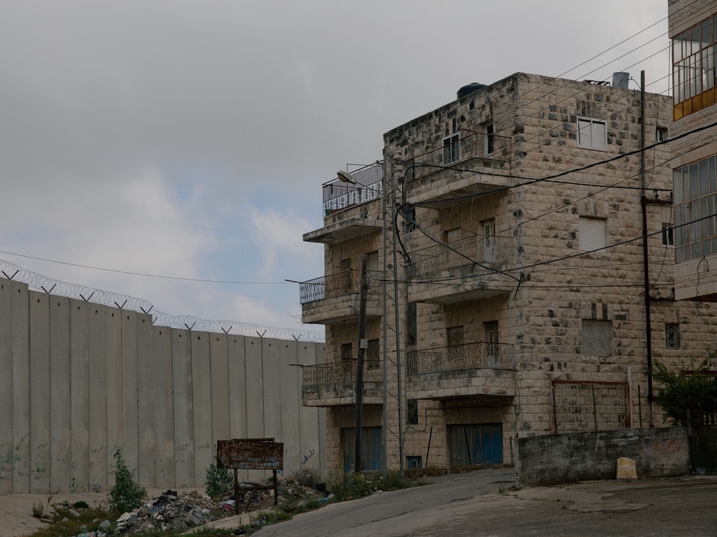 当地时间2023年10月15日，约旦河西岸和以色列之间的隔离墙，靠近拉马拉的居民楼。