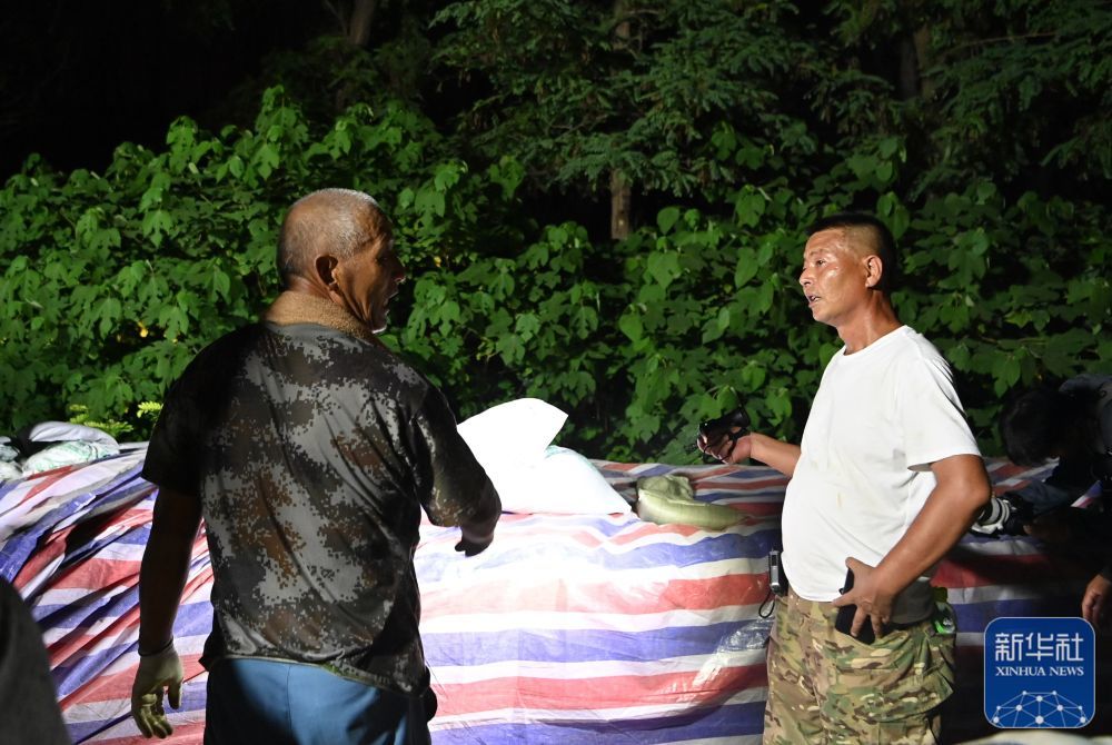 郝庆水（右）在子牙河岸边查看子堤建设进度（8月3日摄）。