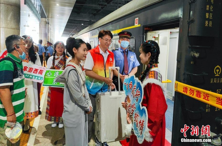 5月28日，北京援藏重点支持项目——2023年首趟“心连心&middot;京藏号”旅游列车载着400多名游客从北京西站发车。该旅游列车全程共计14天，将途经西宁、拉萨、林芝、山南等地。图为工作人员在车厢门口迎候游客乘车。