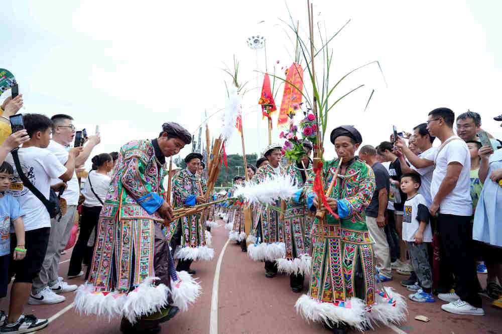 ↑6月23日,村民自发组成的民族歌舞表演队盛装吹芦笙入场。新华社发(王炳真摄)