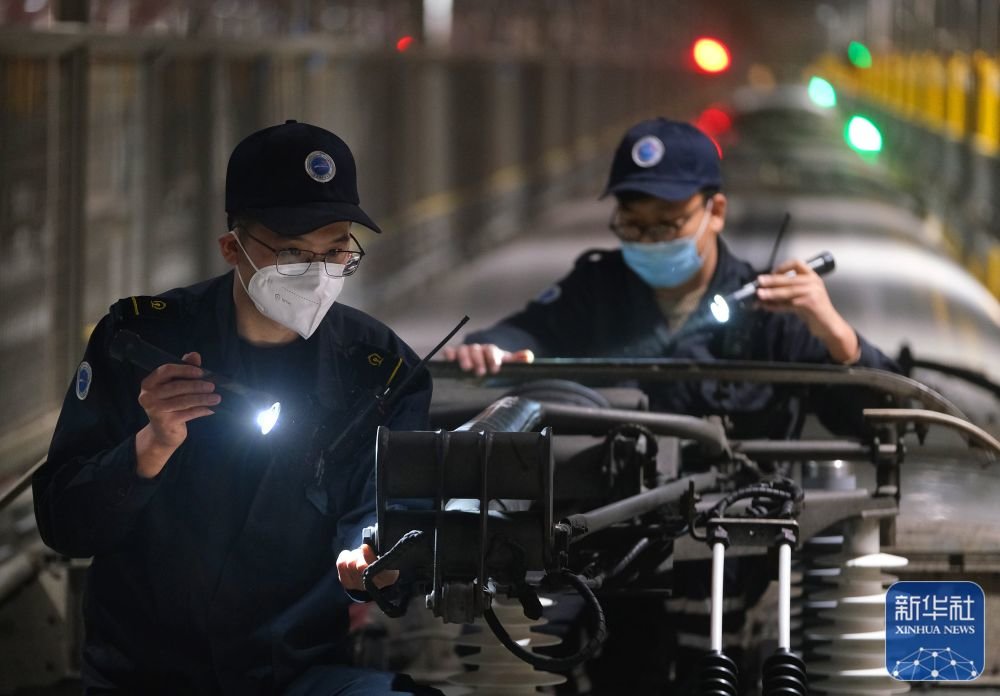 1月21日凌晨,机械师在天津动车客车段动车运用所检修库对进库的动车组列车高压供电系统设备进行检修。新华社发(杨宝森摄)