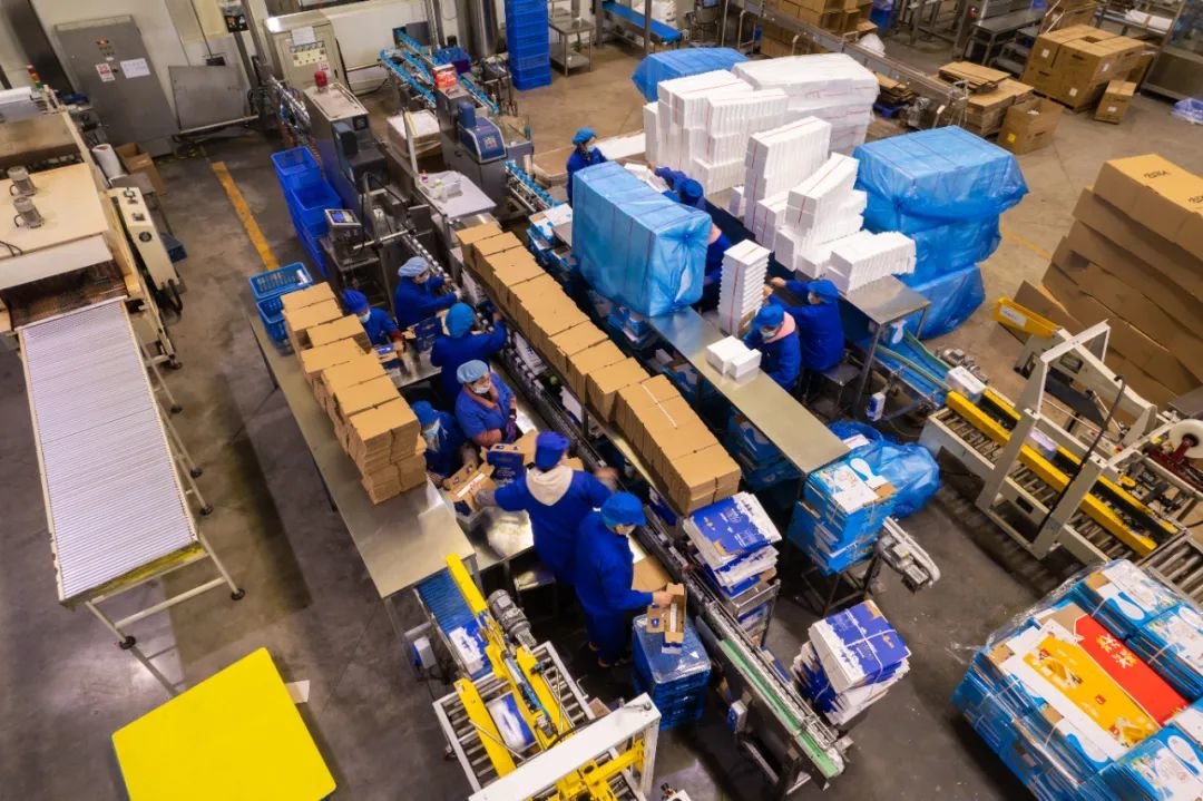 一家食品企业内,工作人员在生产车间包装饮料 陈思汗 摄