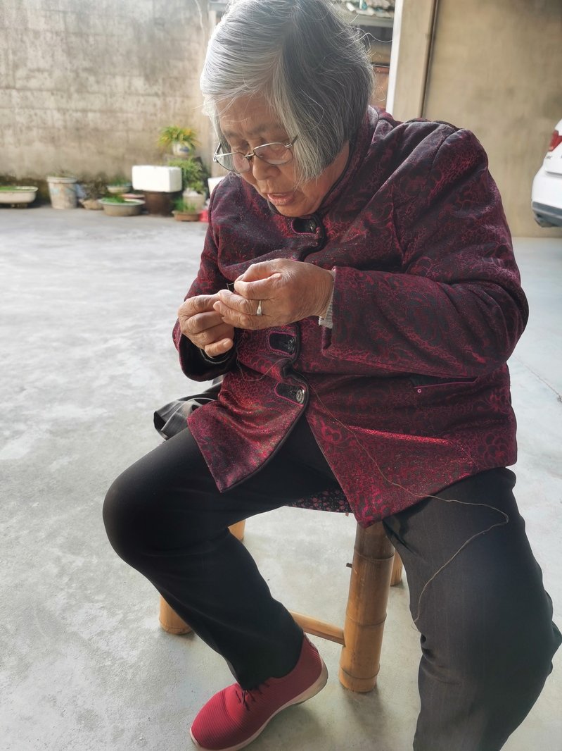 81岁的李彩英正穿针引线,为宣世才改裤子。 本文图片均 雷册渊 摄
