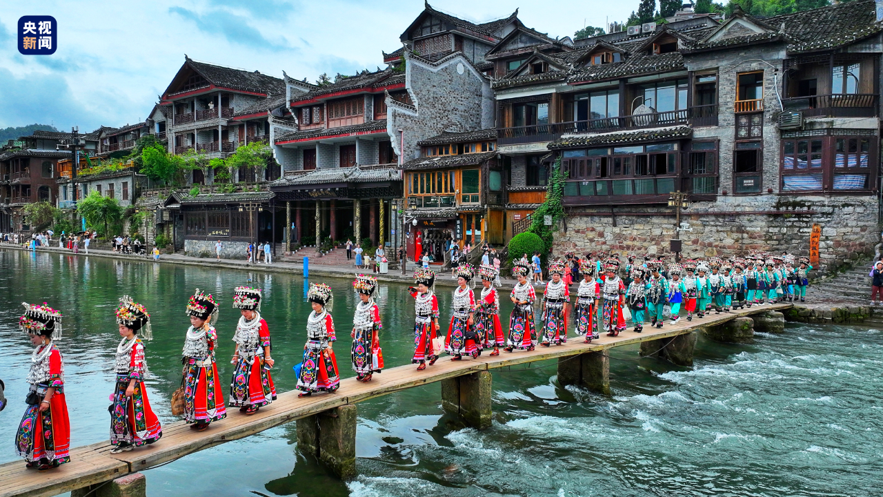 凤凰古城桥上的苗族姑娘穿着苗族服饰