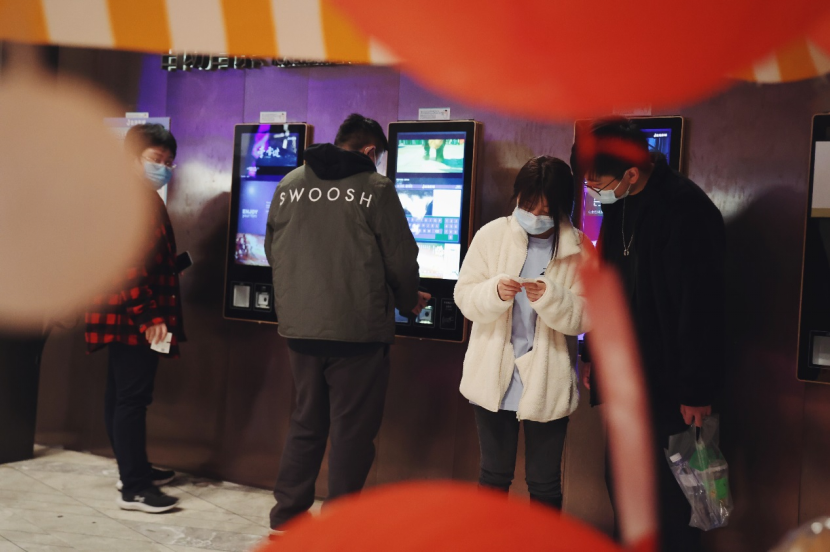 影院内,几位年轻观众在查看电影票的场次信息。/林泽君 摄