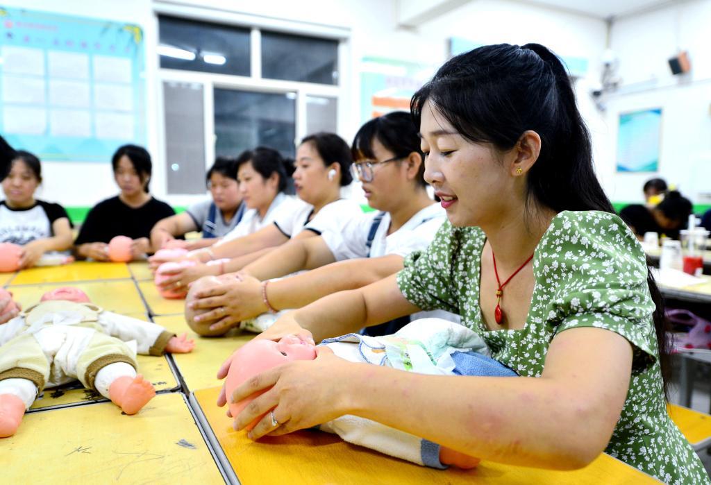 2023年8月22日，学员们在河北省邢台市新河县免费开设的育婴员培训班上学习抚触婴儿的手法。新华社记者 王晓 摄
