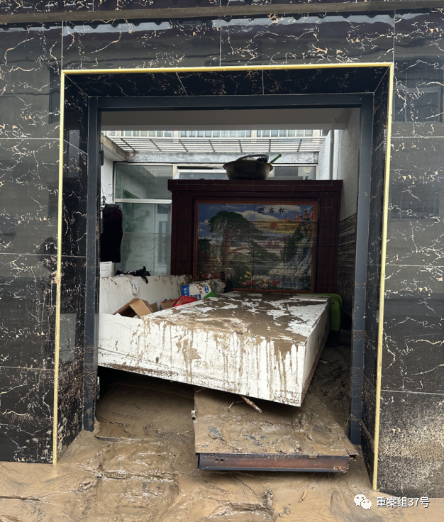 8月1日，水峪嘴村一位村民家的大门被冲坏，院内杂乱不堪。 新京报记者 慕宏举 摄