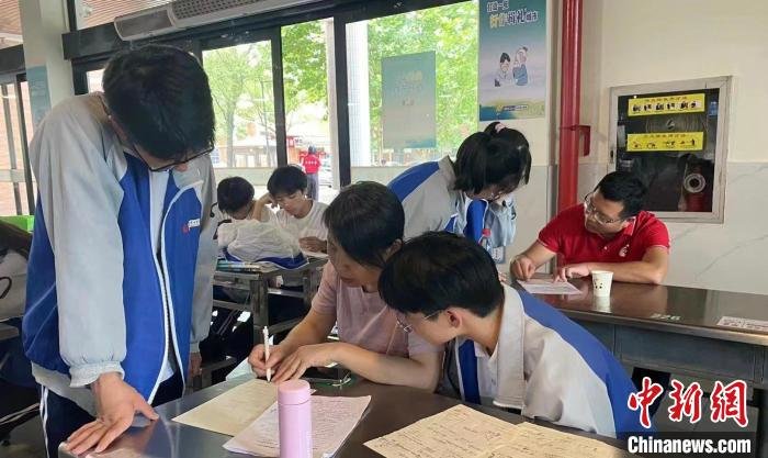 图为：6月7日高考首日，江山市第五中学学生在休息间隙抓紧向老师请教 江山市第五中学供图