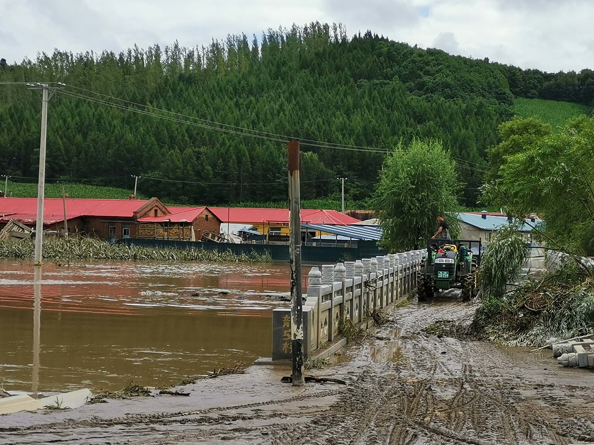 一面坡镇二里地村位于蚂蚁河与一条小河的交汇处，地势较低。8月3日此地也遭了水灾，8月5日村里还有部分房屋泡在水中，村口小河河水几乎与桥面齐平。