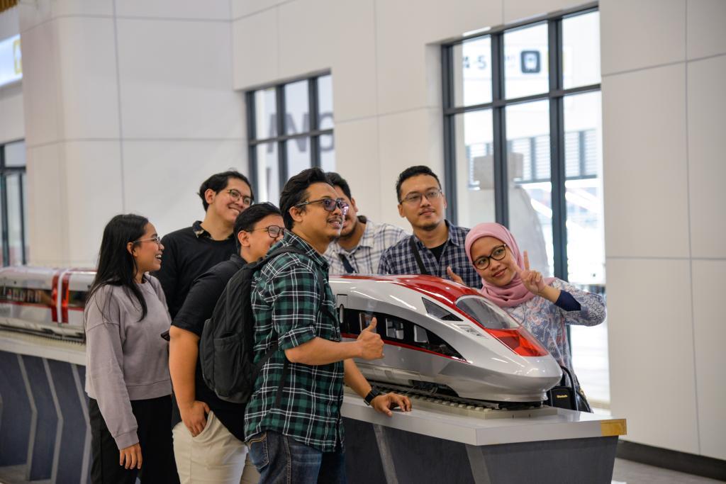 11月17日,在印度尼西亚雅加达的雅万高铁哈利姆站候车大厅,人们和一个雅万高铁高速动车组模型合影。新华社记者徐钦摄