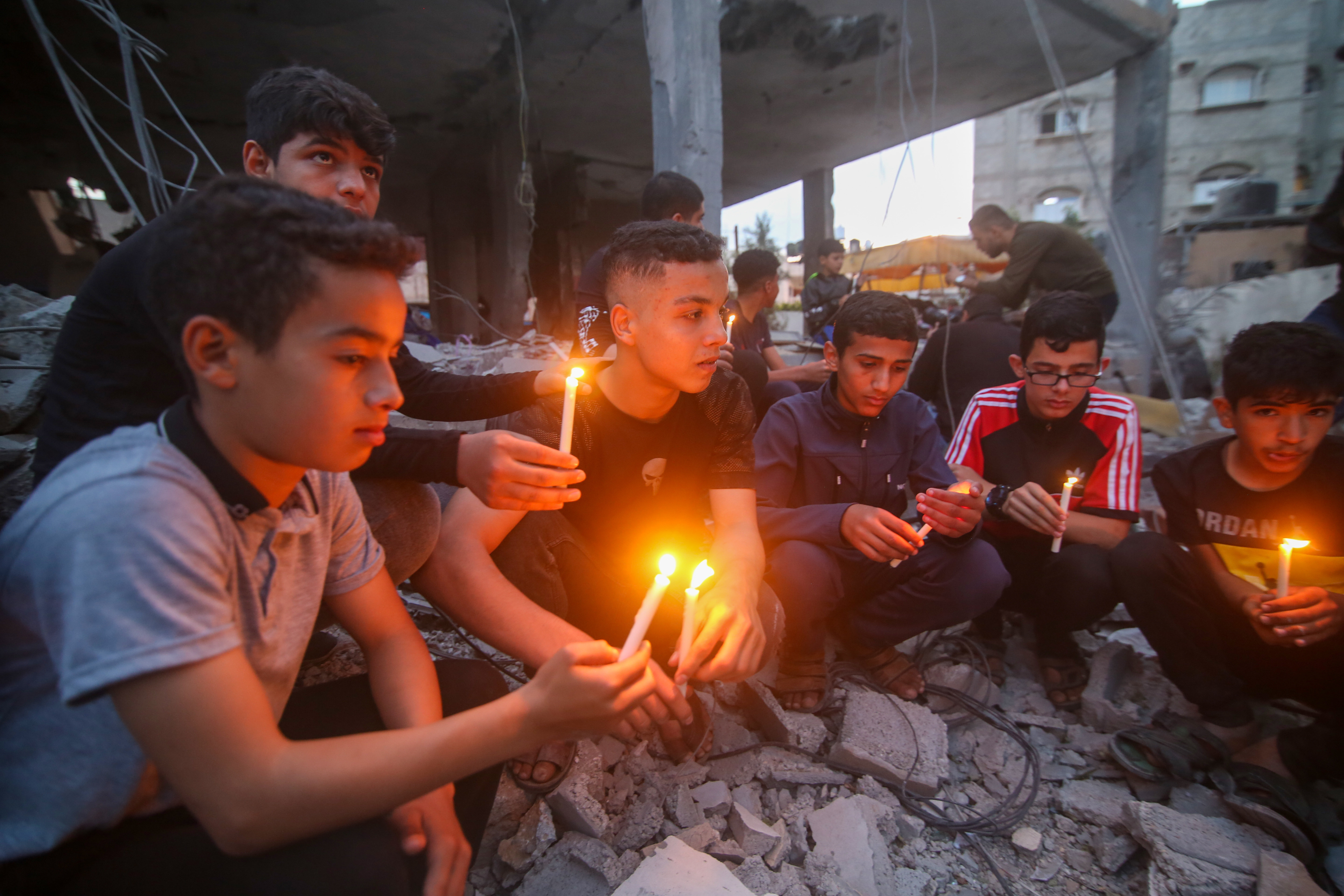 巴以达成停火协议儿童在房屋废墟上点燃蜡烛